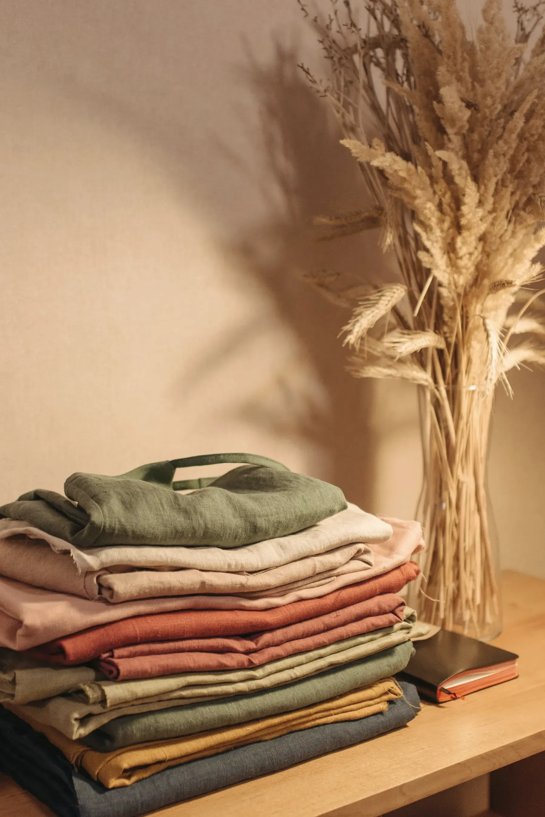 Folded stacks of dyed cotton and linen by a window