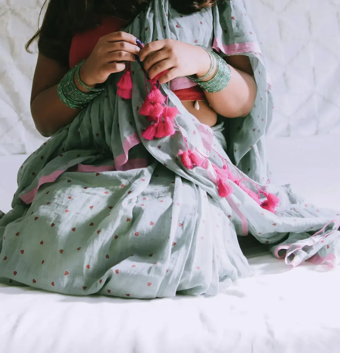 Close view of hand knotted rose tassels on a sage mulmul pallu